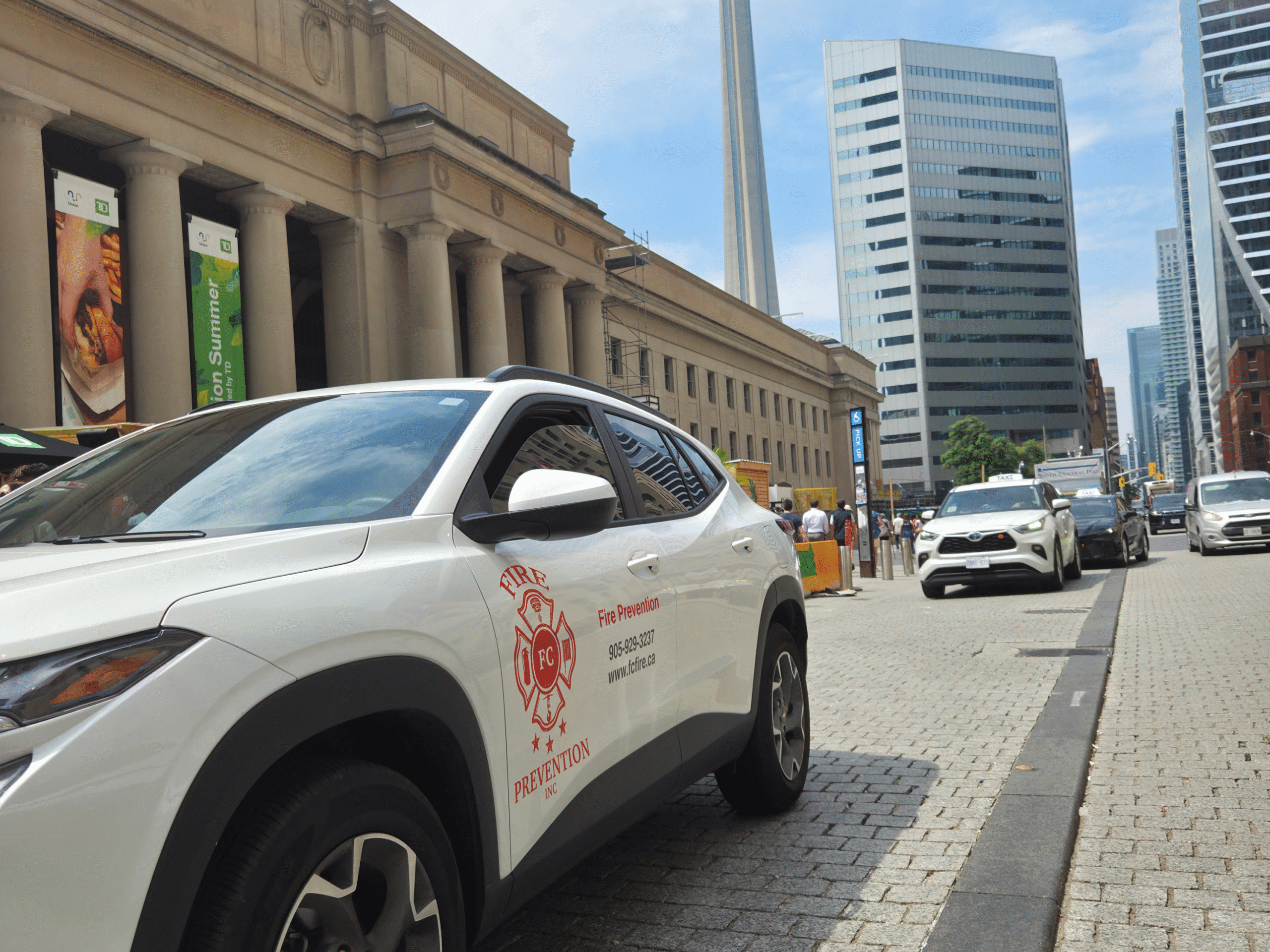White FC Fire Prevention service vehicle parked in front of Union Station with the CN Tower in the background, Toronto, Ontario.